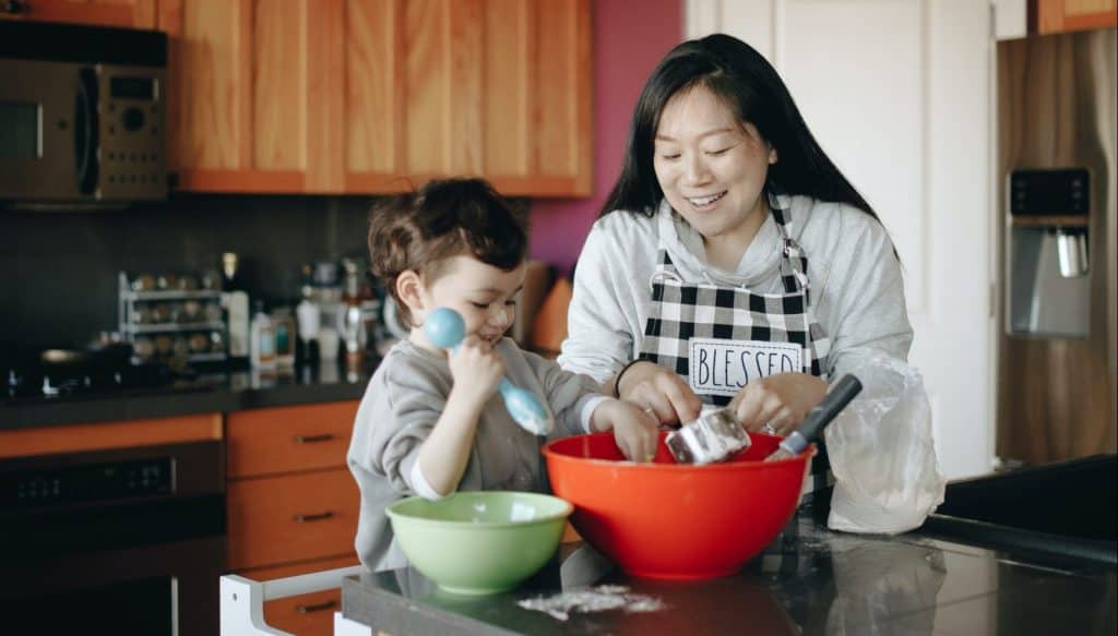 toddler baking with his mom