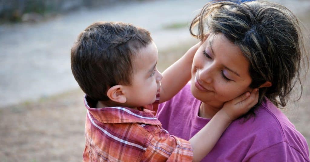 toddler holding his mom's face