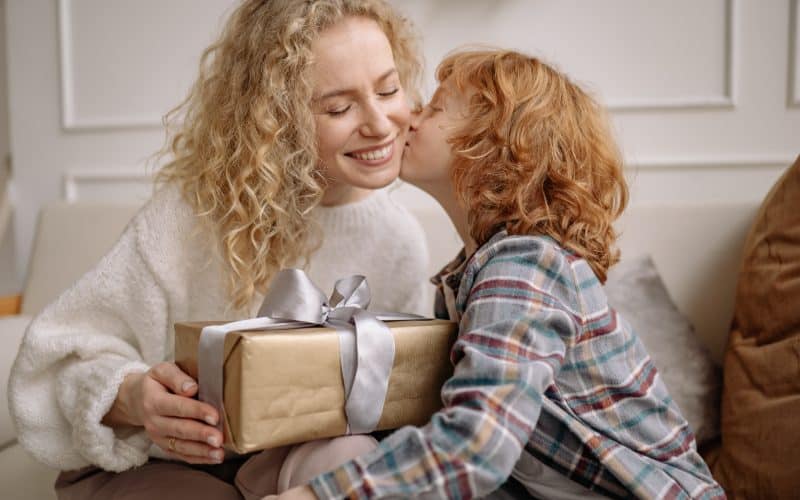 boy giving a gift to mom