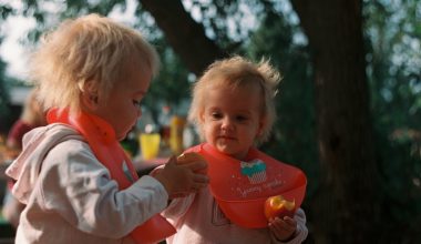 cute babies eating apple and wearing bibs