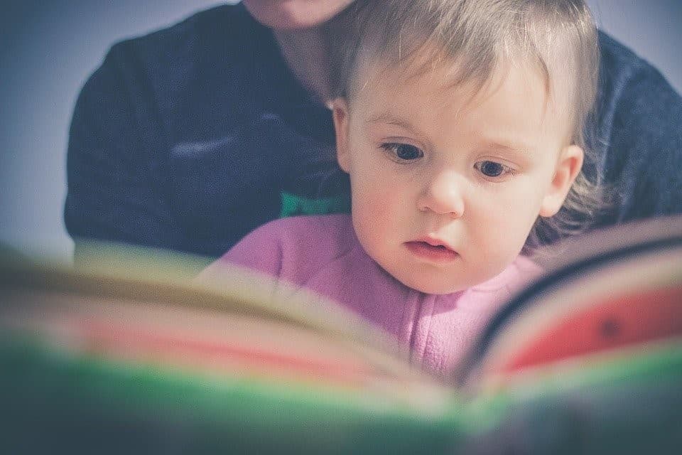 dad reading bedtime story to baby girl