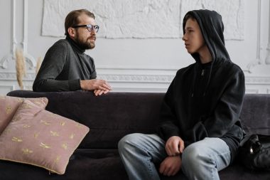 dad talking to his son on the sofa