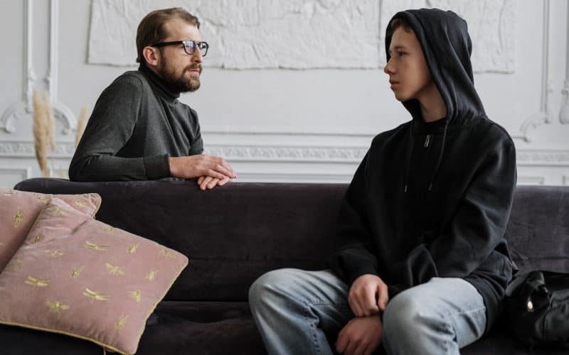 dad talking to his son on the sofa
