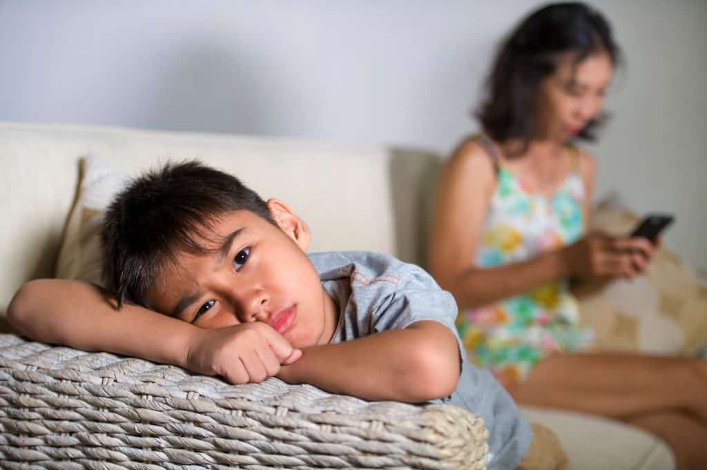 frustrated boy while mom on the phone