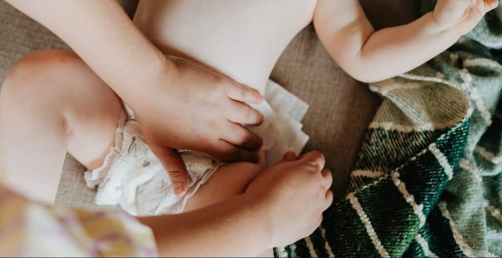 mother changing baby's diaper