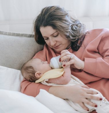 mother feeding bottle of milk to baby
