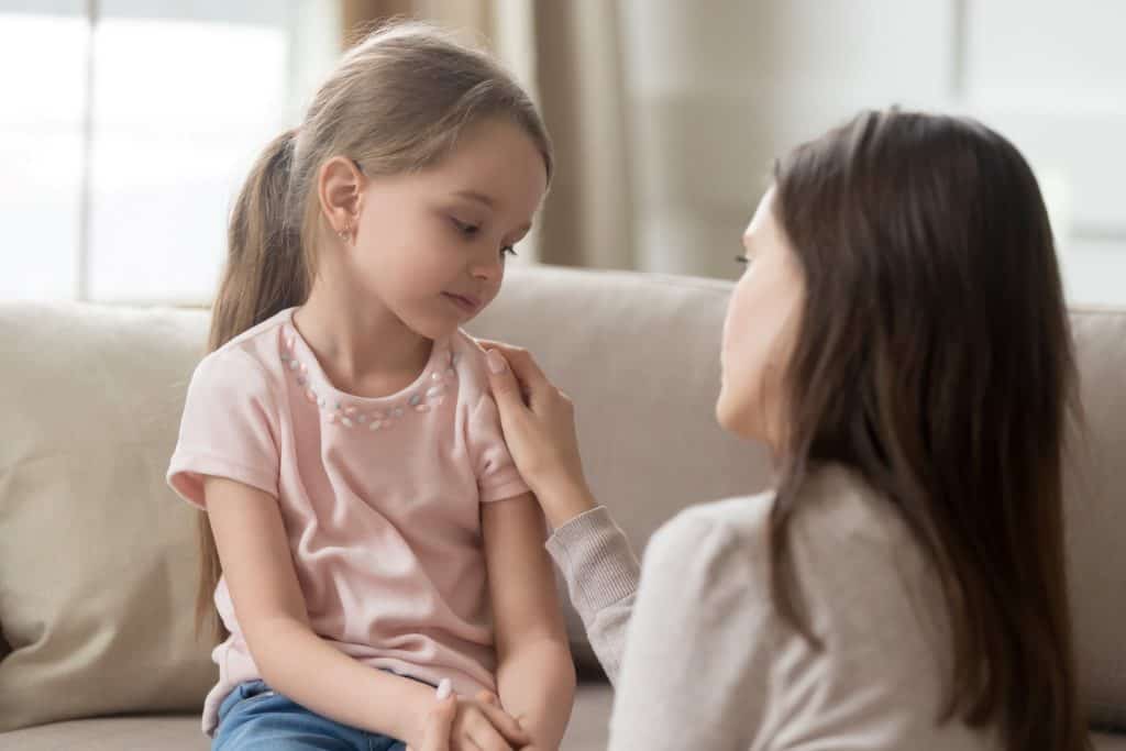 mother talking to her daughter on the couch