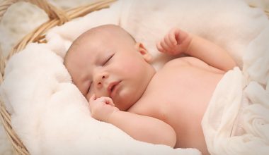 sleeping baby on a basket filled with white cotton