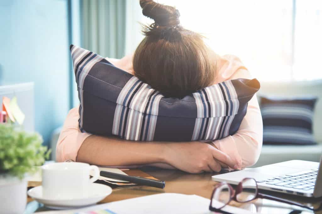 woman burrowing her head on a pillow