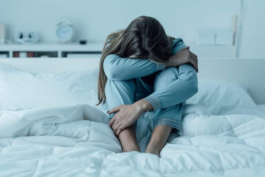 woman crying on her bed