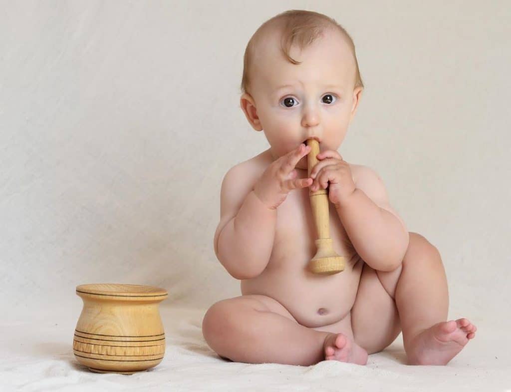 baby holding wooden mallet