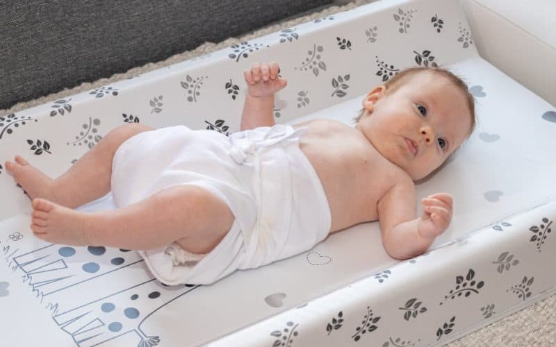 baby lying on a diaper changing pad