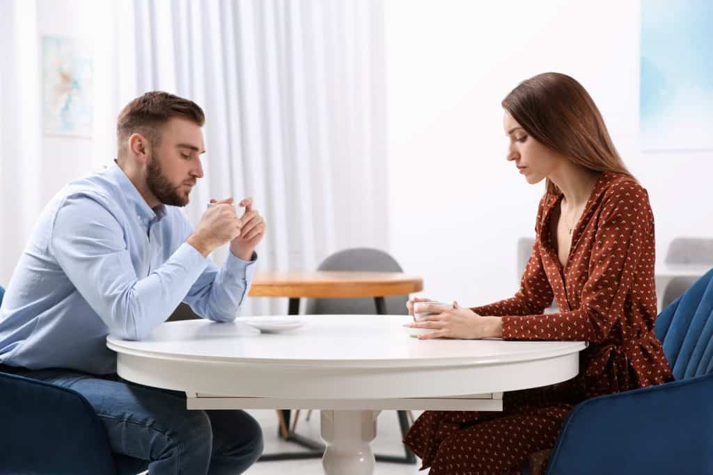 man and woman looking at their coffee