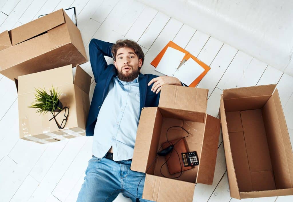 man surrounded with boxes