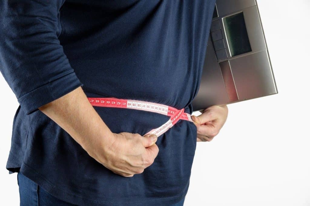 woman measuring her own waist