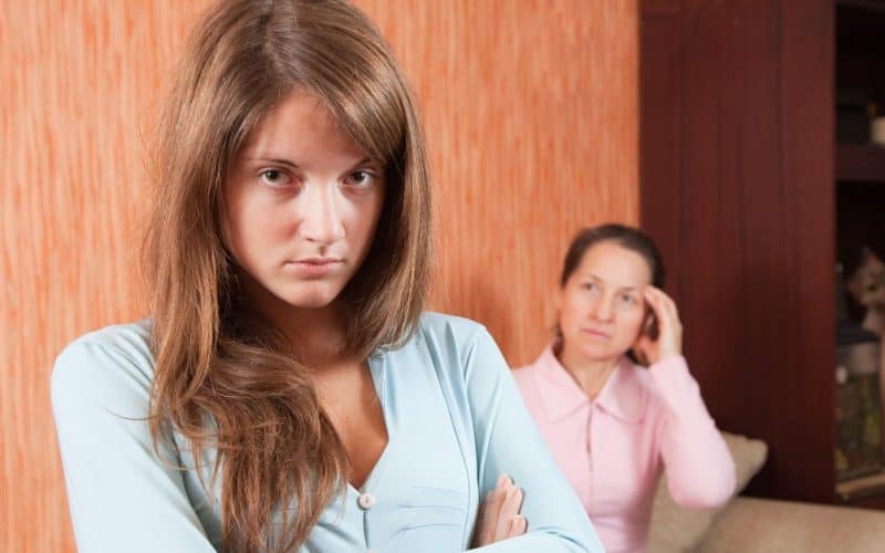 angry teenage girl and stressed out mom