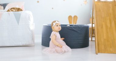 baby girl sitting in a children's room