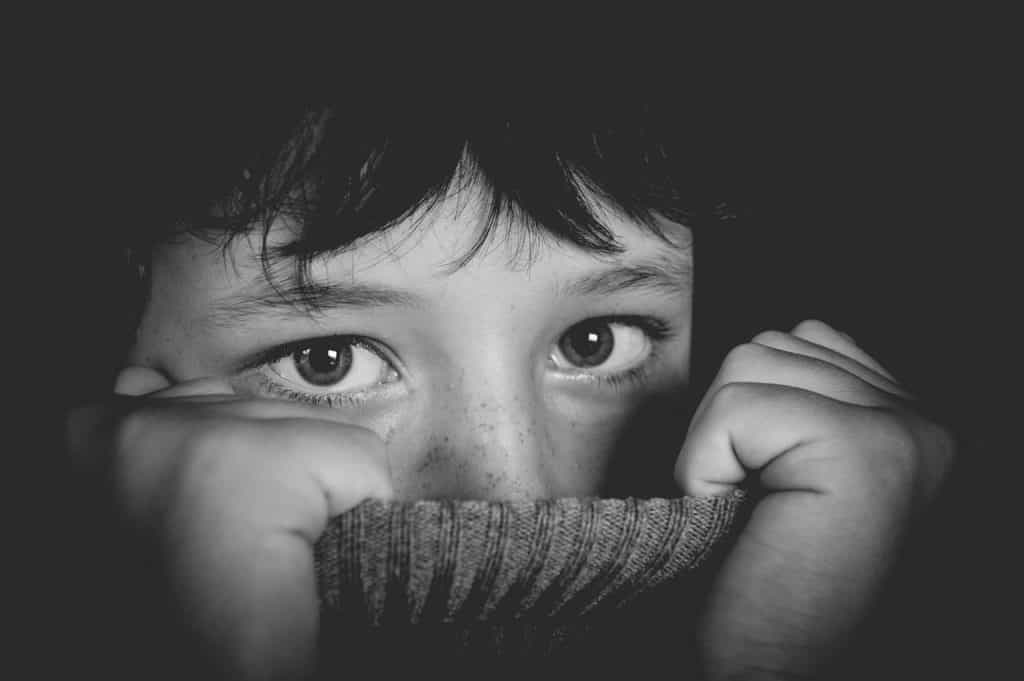 boy hiding his face on his turtleneck top