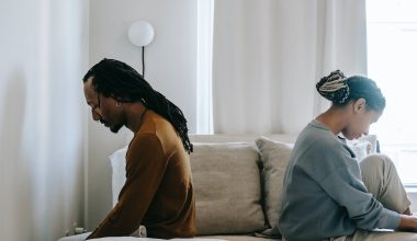 couple sitting on opposite side of the bed