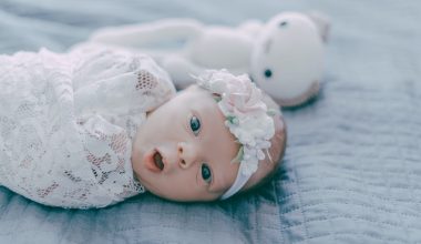 cute baby swaddled by embroidered cloth