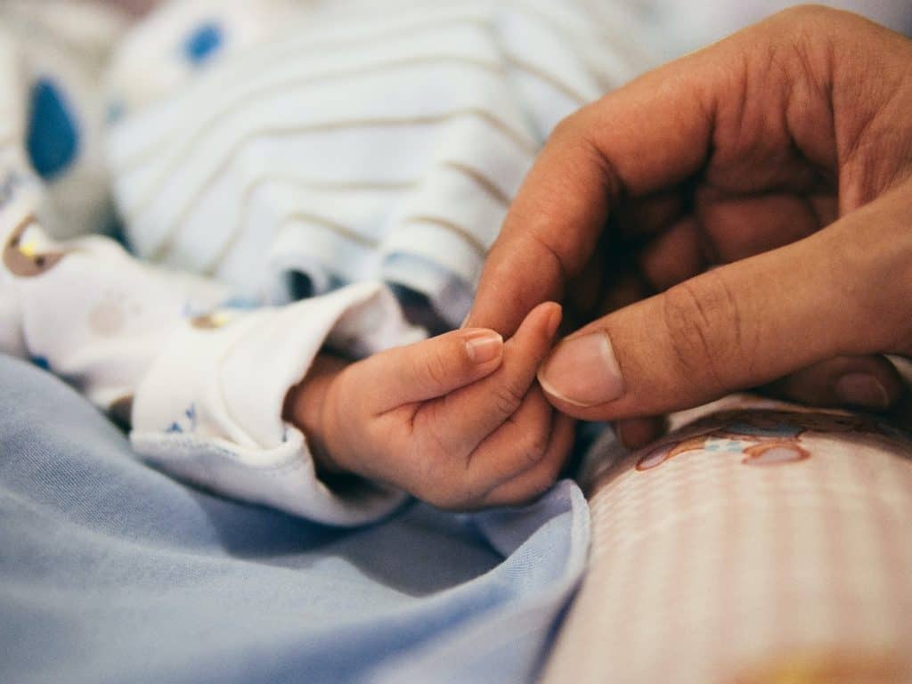 dad holding baby's hands