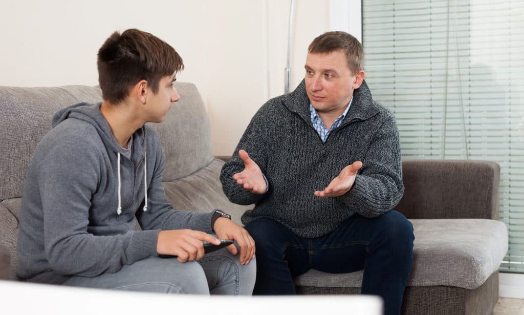 father and son talking on the couch