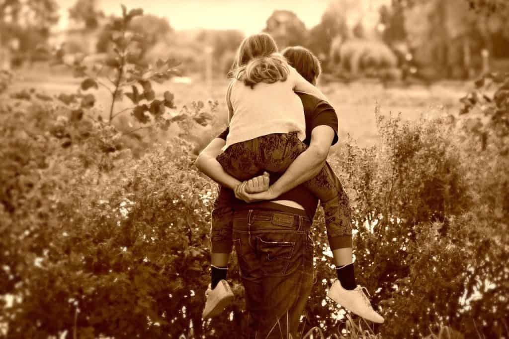 father carrying his daughter on his back