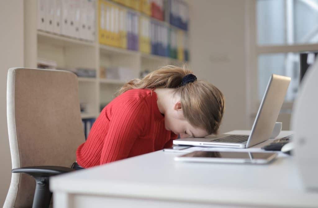 girl leaning her head on a laptop