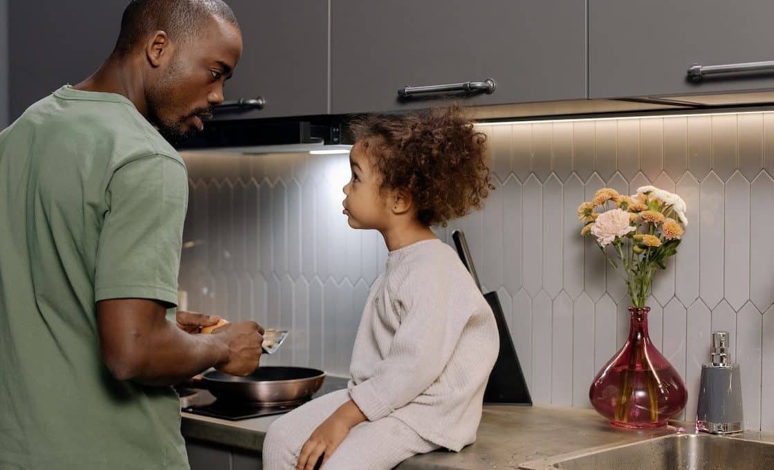 little girl and father talking in the kitchen