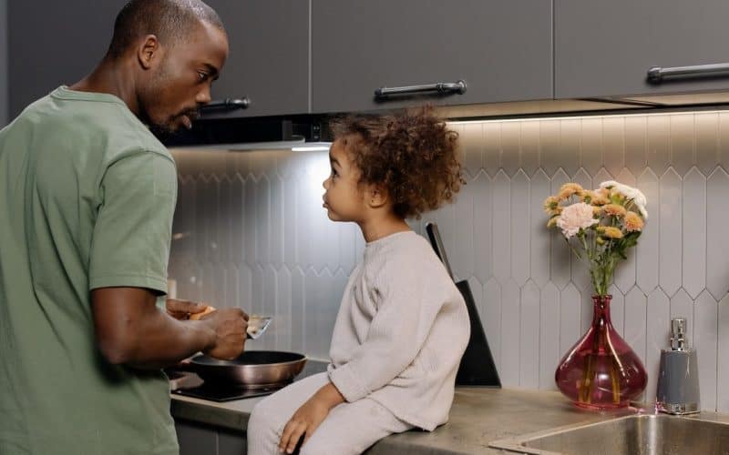little girl and father talking in the kitchen