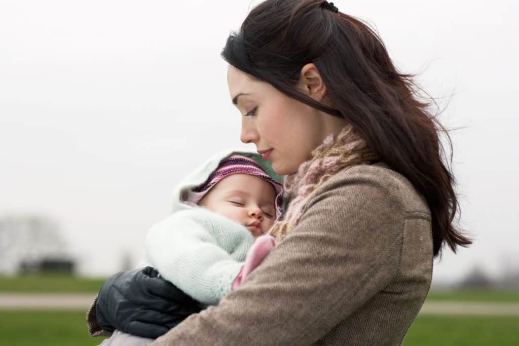 mom carrying baby outdoors