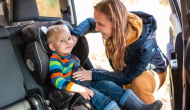 mom fastening baby's seat belt