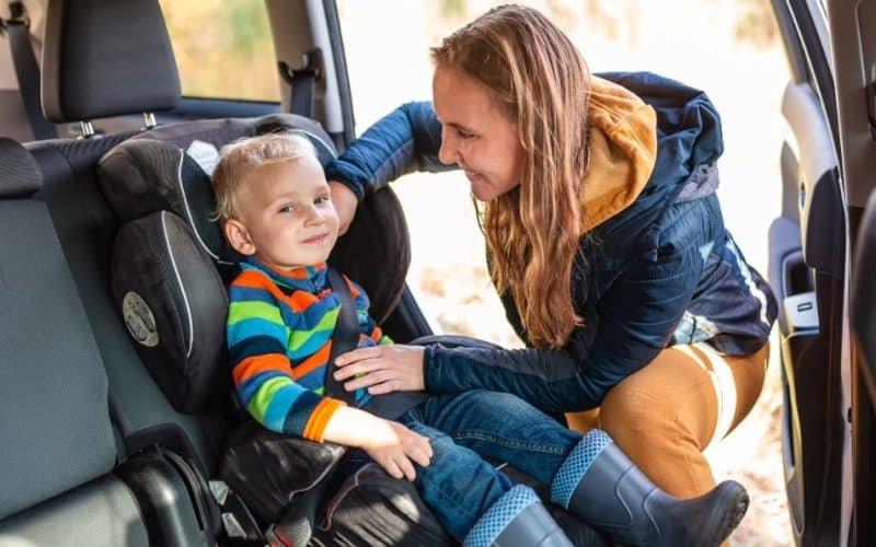 mom fastening baby's seat belt