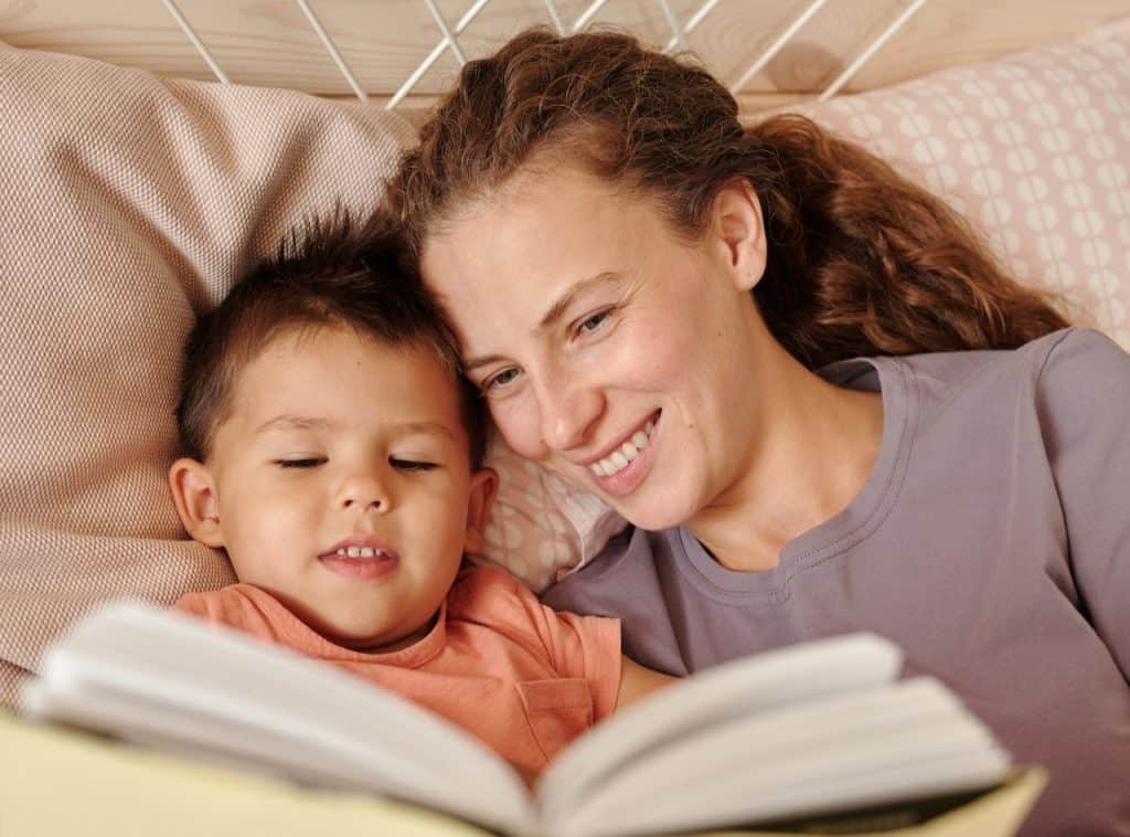 mom reading book to her son