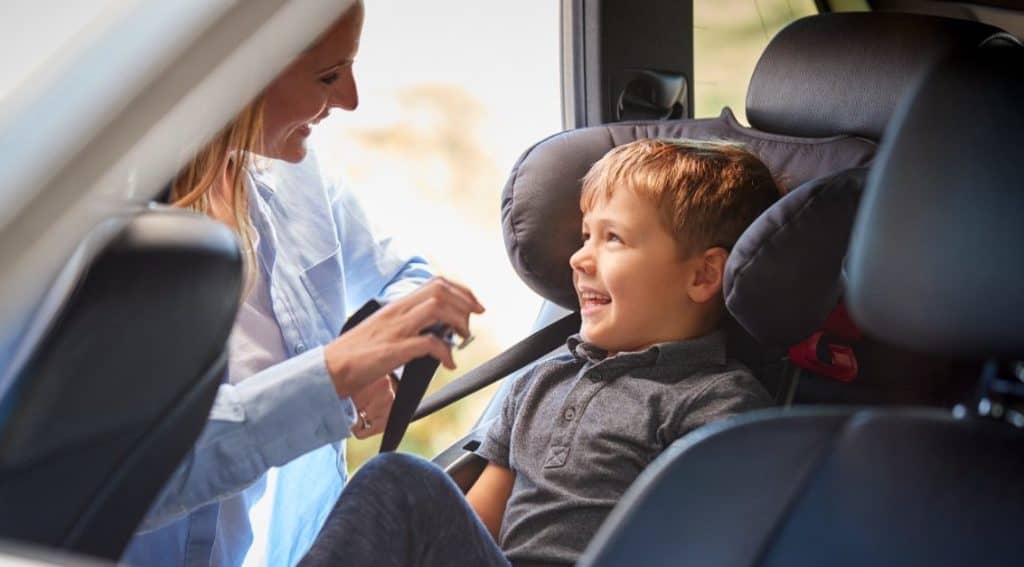 mom securing toddler's seat belt