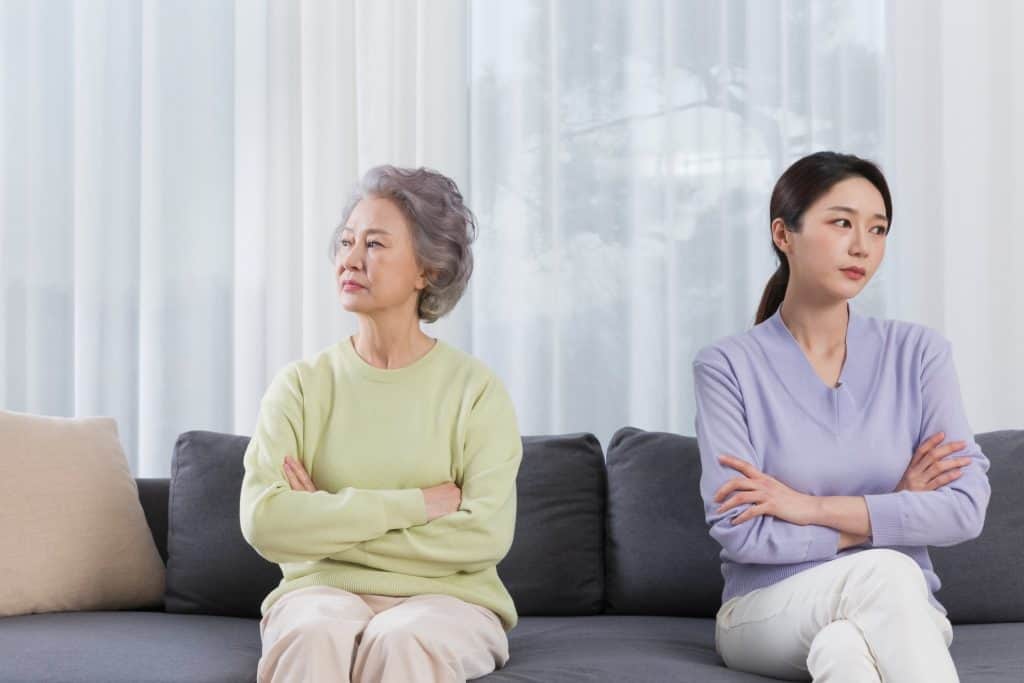 mother and daughter ignoring each other on the couch
