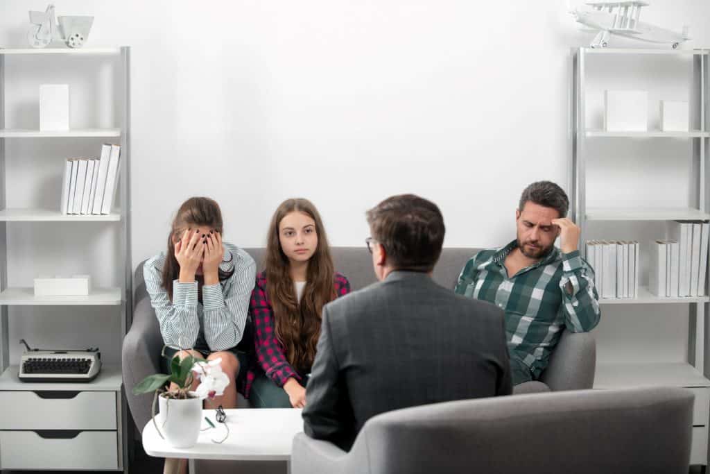 parents and teenage girl talking to a therapist