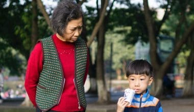 toddler standing beside his grandma