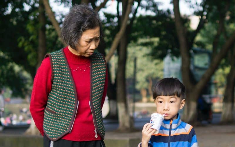 toddler standing beside his grandma
