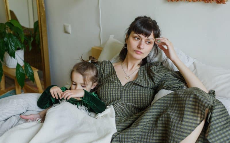 woman on bed with daughter questioning her life choices