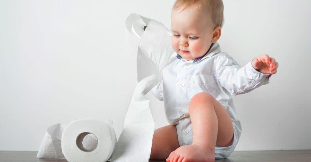 baby playing with toilet paper