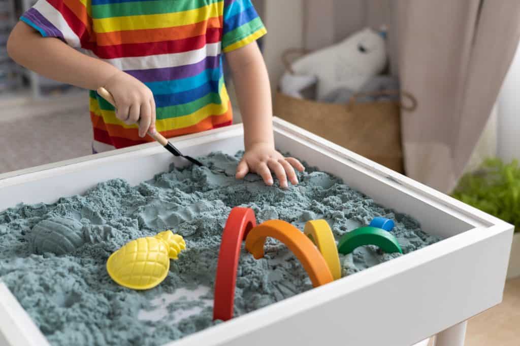 boy playing with kinetic sand