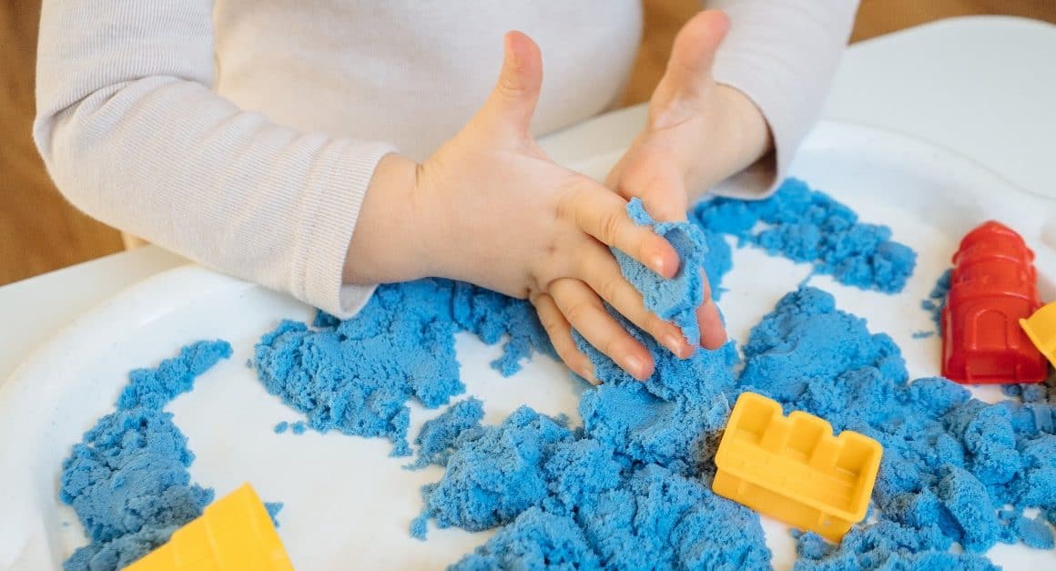 child playing with blue kinetic sand