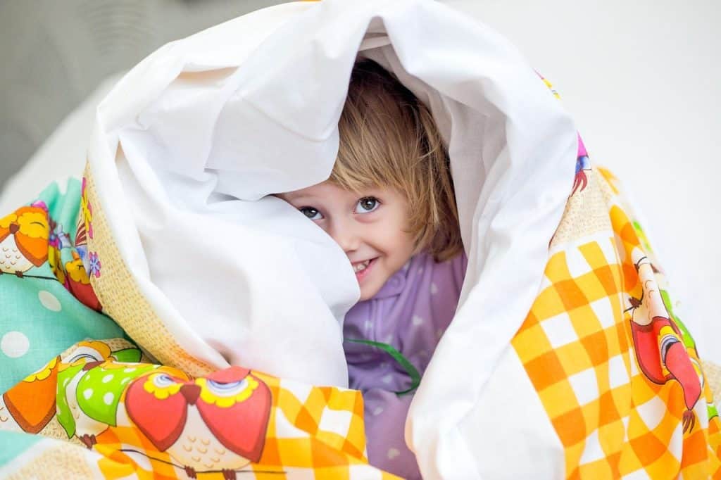 girl hiding under a blanket