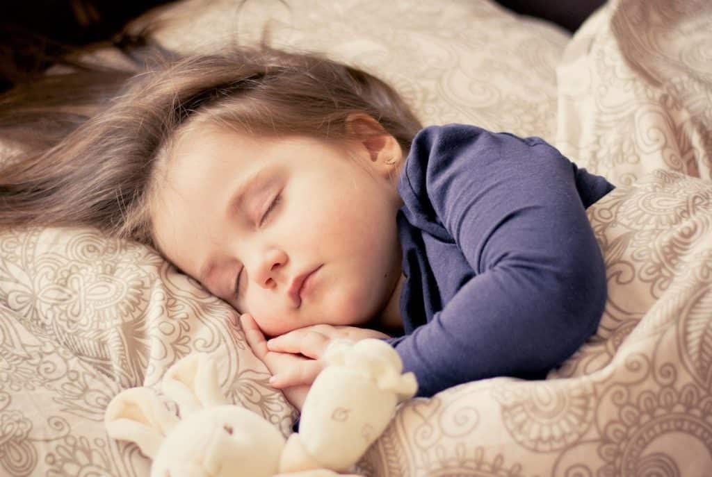 little girl sleeping in her bed