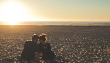 man and woman sitting on the beach