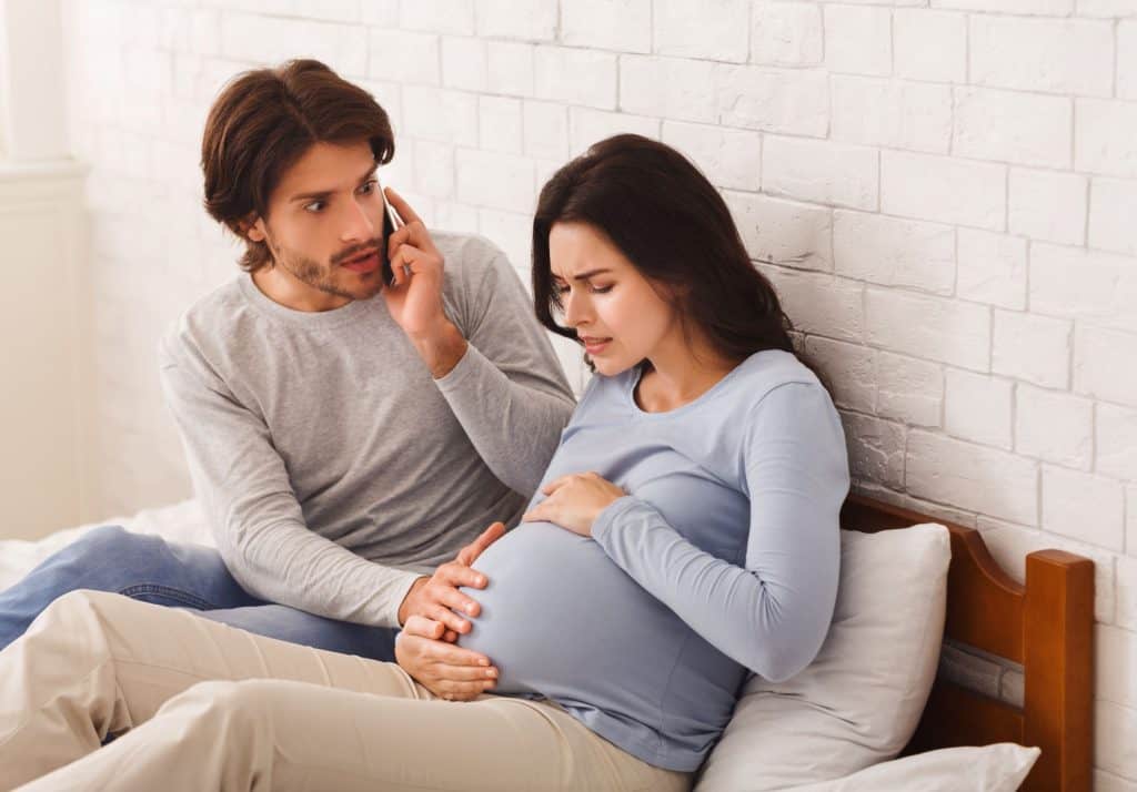 man calling ambulance woman about to give birth