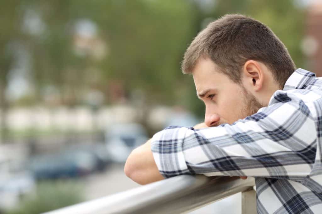 man crouching on a railing