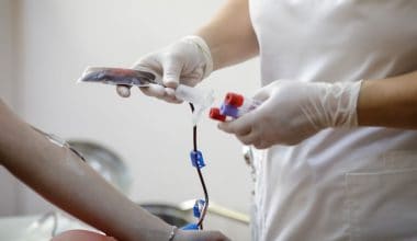 medical worker preparing a volunteer for donating blood
