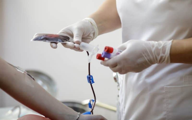 medical worker preparing a volunteer for donating blood
